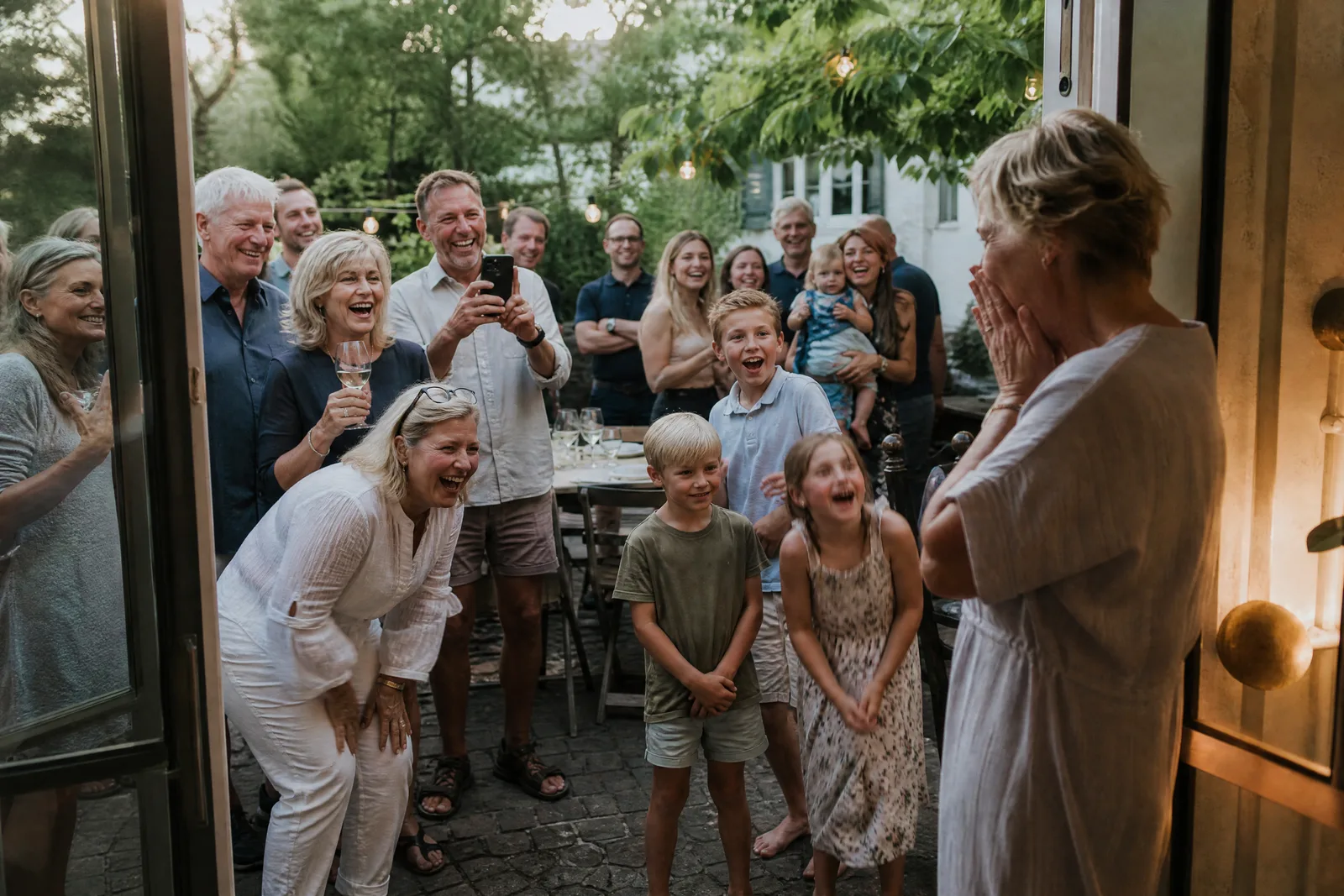Eine Frau wird zu ihrem sechzigsten Geburtstag von Familie und Freunden überrascht