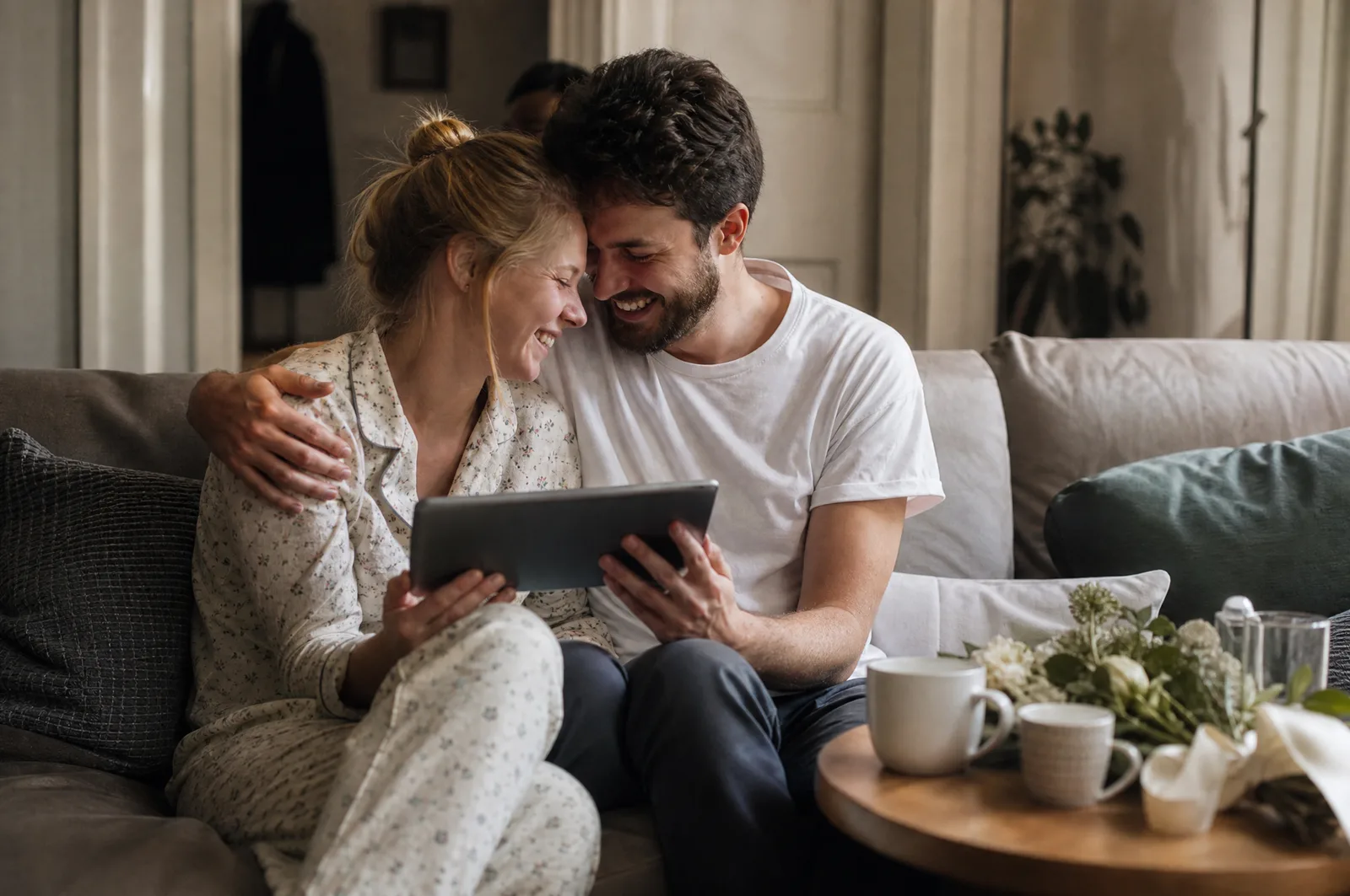 Ein frisch verheiratetes Paar sieht sich am Morgen danach auf dem Sofa die Gästefotos an